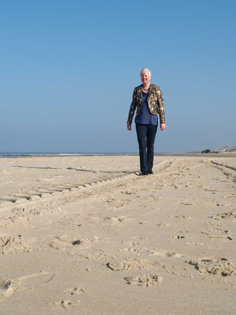 margrete stoute boots wandelend over het strand